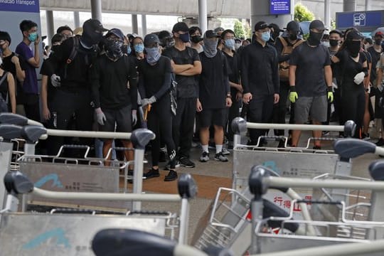 Demonstranten blockieren eine Straße vor dem Hongkonger Flughafen.