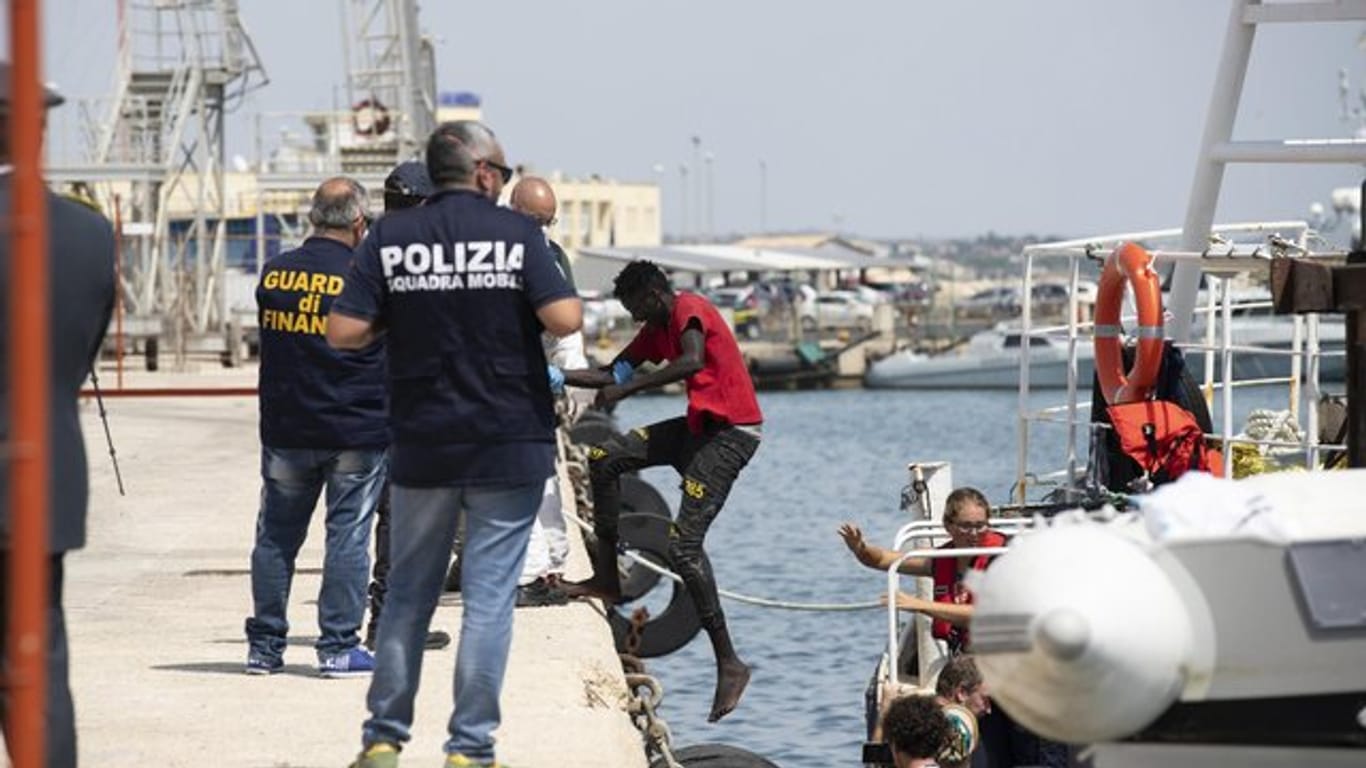 Migranten verlassen die "Eleonore" im Hafen von Pozzallo.