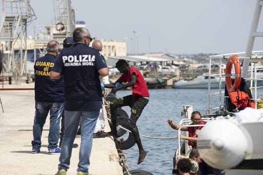 Migranten verlassen die "Eleonore" im Hafen von Pozzallo.