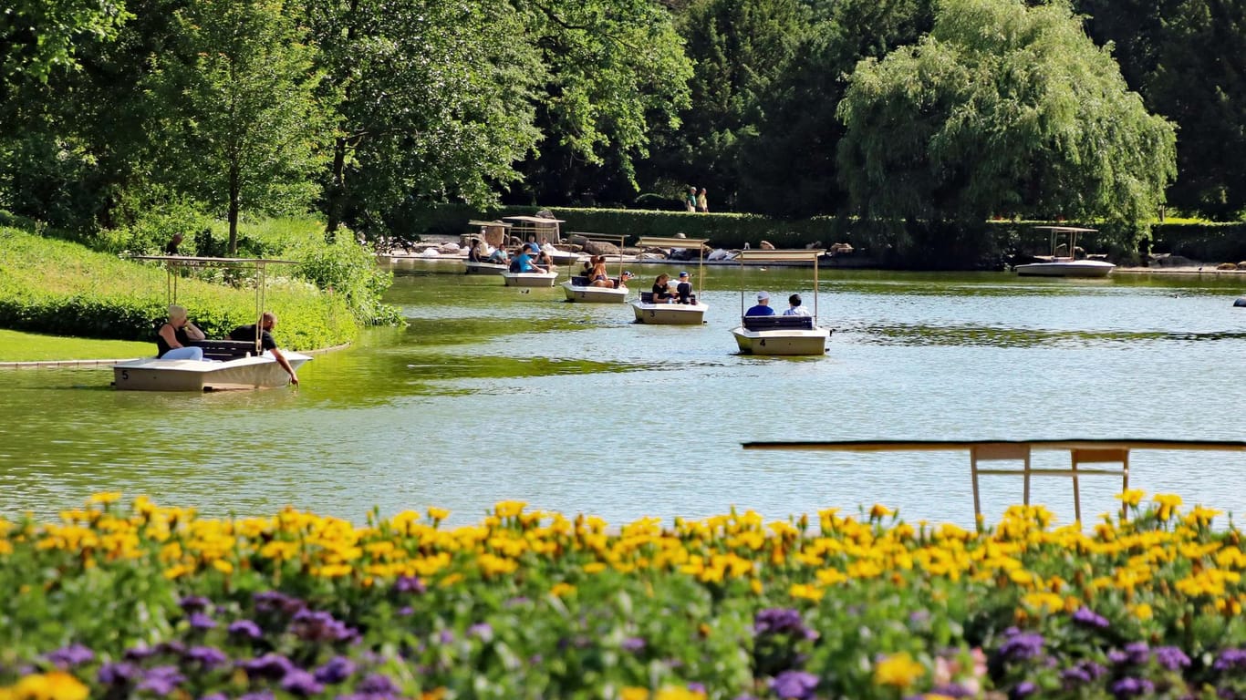 Mehrere kleine Boote dümpeln auf einem See in einem Park: Die Gondoletta ist ein beliebte Attraktion in Karlsruhe.