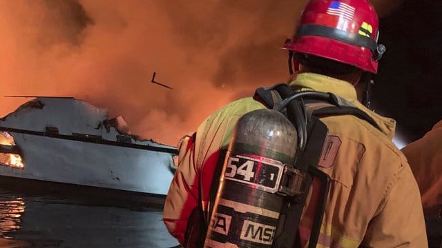Ein Feuerwehrmann bekämpft den Bootsbrand vor der Küste Südkaliforniens. Ein Feuerwehrmann bekämpft den Bootsbrand vor der Küste Südkaliforniens.