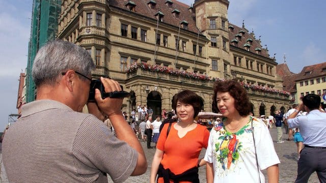 Japanische Touristen vor dem Renaissance-Rathaus in Rothenburg ob der Tauber.