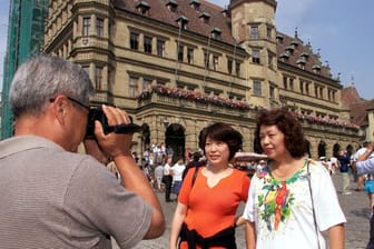 Japanische Touristen vor dem Renaissance-Rathaus in Rothenburg ob der Tauber.