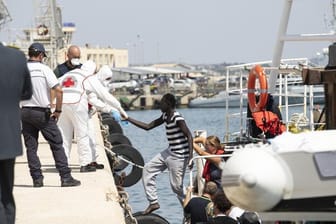 Migranten verlassen im Hafen von Pozzallo auf Sizilien das deutsche Rettungsschiff Eleonore.