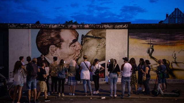 Touristen und Besucher stehen vor dem sogenannten "Bruderkussgemälde" an der East Side Gallery. Touristen und Besucher stehen vor dem sogenannten "Bruderkussgemälde" an der East Side Gallery.