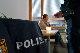 Eine Frau bei einer Polizeikontrolle (Symbolbild): Auf dem Tisch befindet sich eine Urinprobe für einen Drogentest.