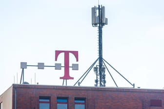 Ein Mobilfunkmast steht auf einem Gebäude mit dem Telekom-Logo: Die ersten 5G-Frequenzen wurden zugeteilt.