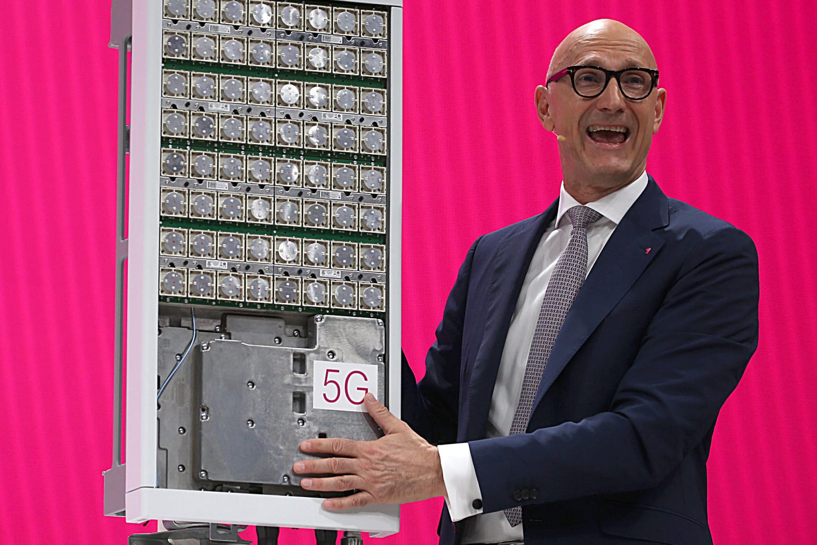 Telekom-Chef Timotheus Höttges spricht neben einer 5G Antenne: Kunden der Deutschen Telekom können nun auch im 5G-Mobilfunkstandard mobil surfen.