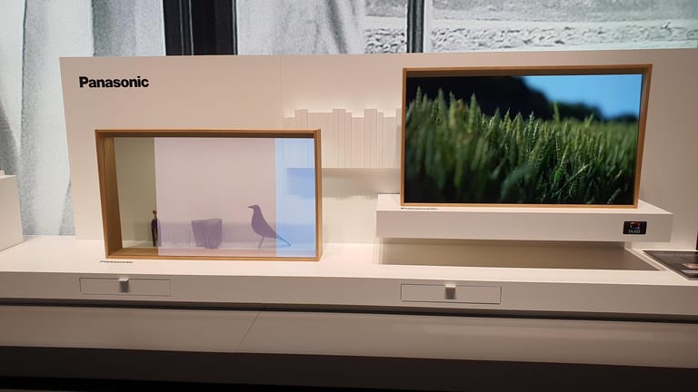 Panasonics transparenter OLED: Rechts zeigt das Gerät ein Bild, links ist es halb transparent, sodass die Figuren hinter dem Bildschirm gesehen werden können. Der Bildschirm lässt sich auch vollständig ausschalten.