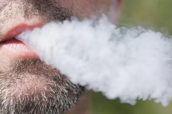 Rauch aus einem Mund: In den USA gibt es immer mehr Meldungen ungeklärter Lungenerkrankungen, die nach dem Konsum von E-Zigaretten auftreten.