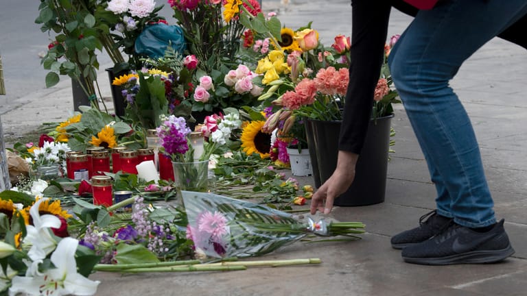 Eine Frau legt Blumen an der Stelle ab, an der vier Menschen bei einem Verkehrsunfall gestorben waren.