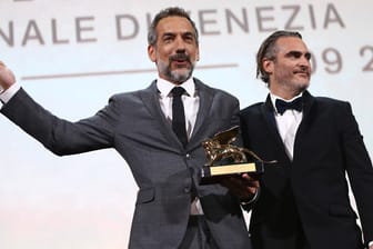 Regisseur Todd Phillips (l) hält neben Schauspieler Joaquin Phoenix den Goldenen Löwen in der Hand.