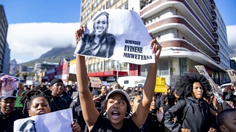 Eine Frau mit dem Bild der kürzlich vergewaltigten und getöteten 19-jährigen Studentin der Universität Kapstadt, Uyinene Mrwetyana.