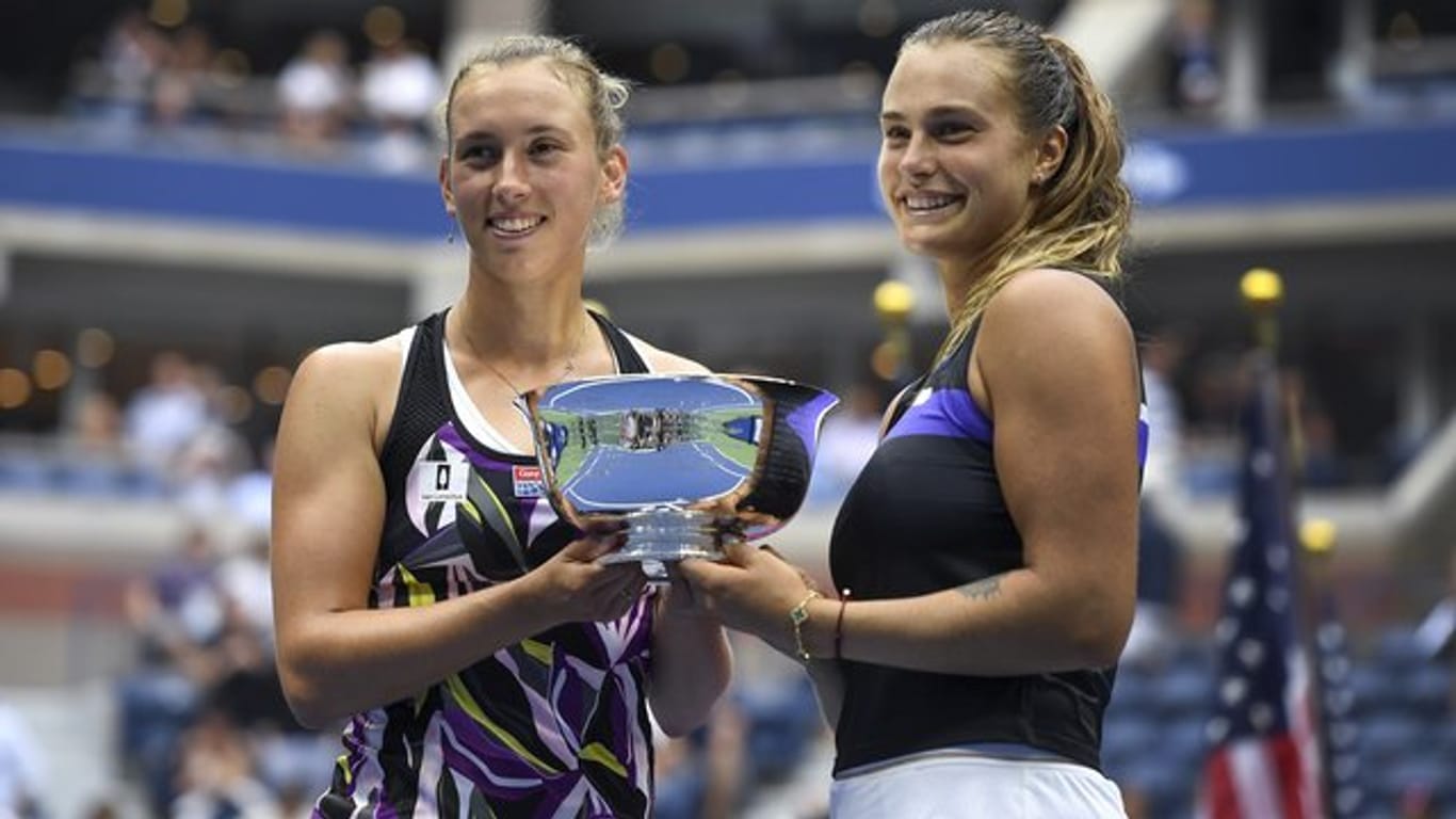 Aryna Sabalenka (r) und Elise Mertens halten nach ihrem Sieg im Doppel bei den US Open die Trophäe in den Händen.