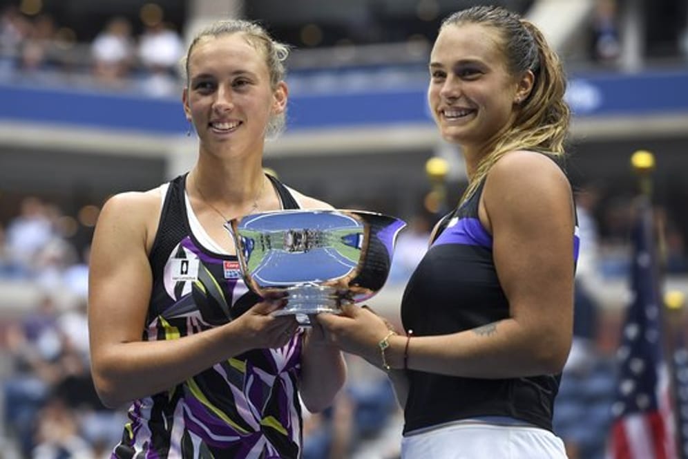 Aryna Sabalenka (r) und Elise Mertens halten nach ihrem Sieg im Doppel bei den US Open die Trophäe in den Händen.