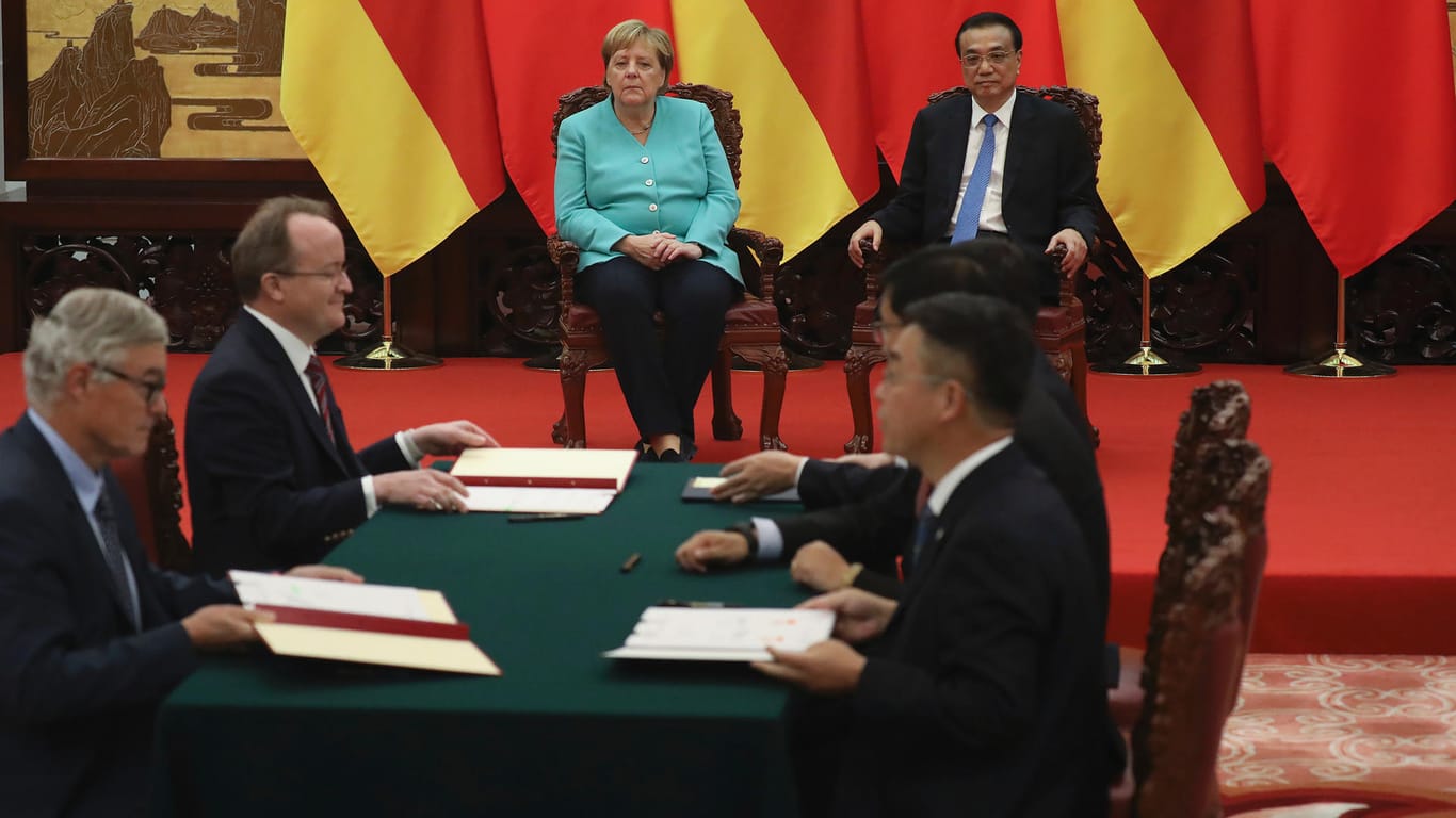 Deutsche und chinesische Firmenchefs unterzeichnen Verträge – unter den Augen von Kanzlerin Merkel und Ministerpräsident Li.
