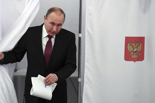 Präsident Wladimir Putin kommt in Moskau aus der Wahlkabine.