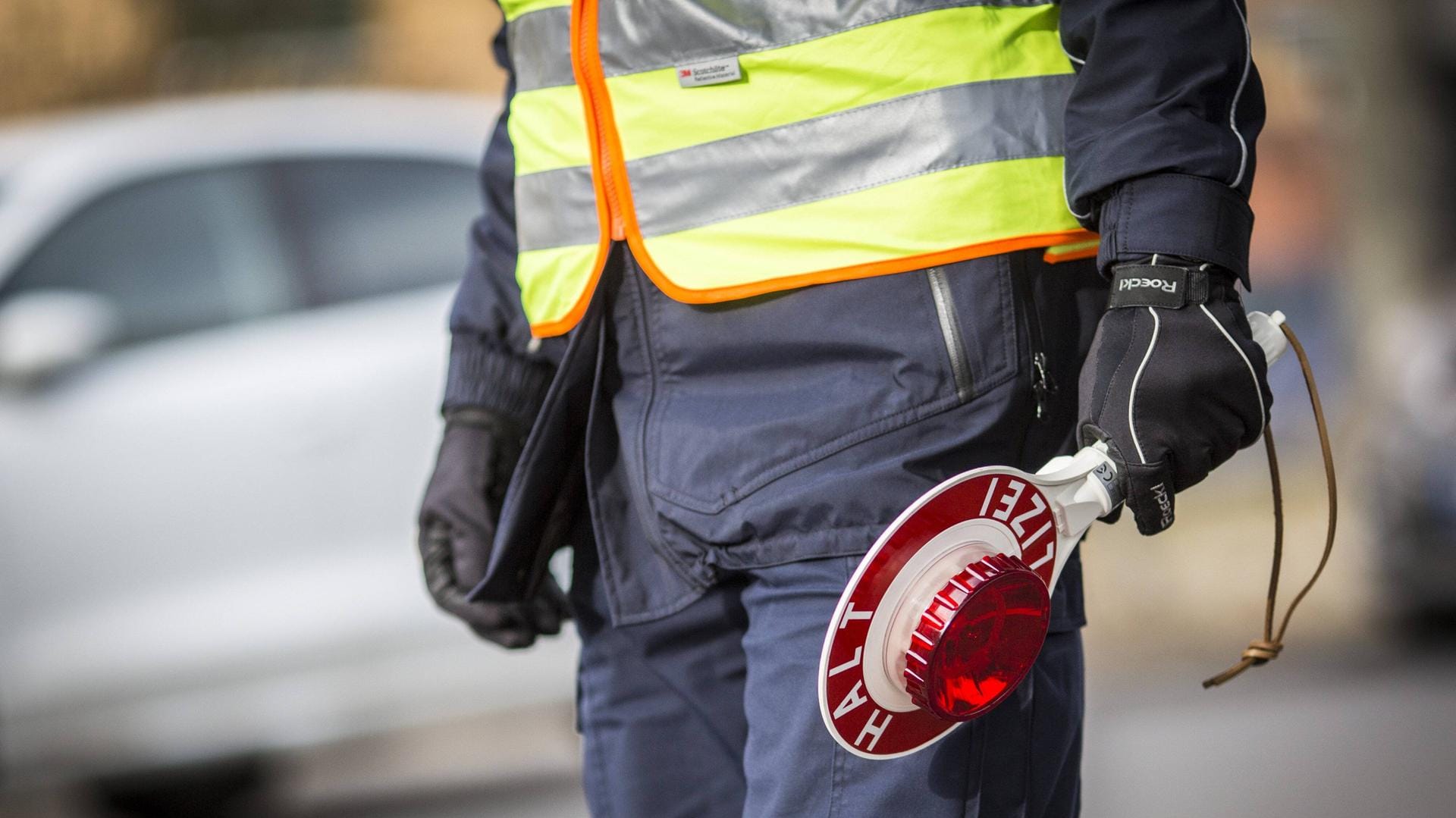 Ein Polizeibeamter mit Polizeikelle: In Dortmund ist ein Autofahrer betrunken, offenbar mit Drogen im Blut und ohne Führerschein durch die Stadt gefahren. (Symbolbild)