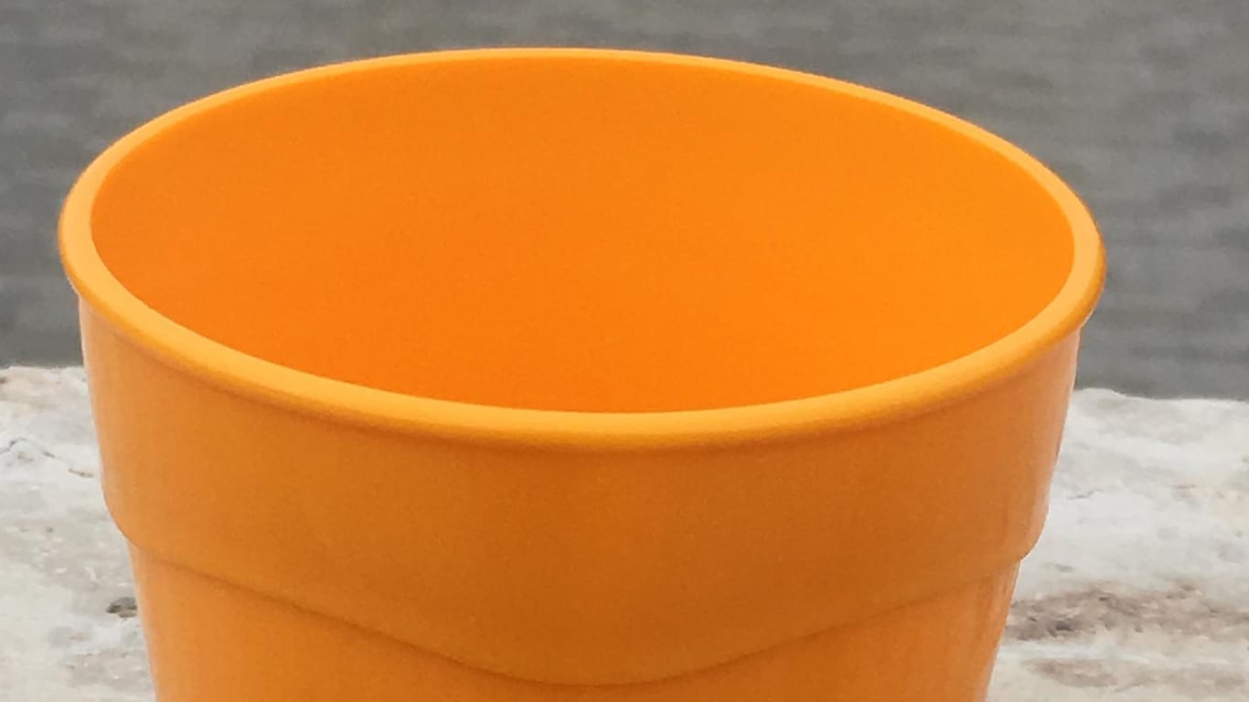 Ein orangener Kaffeebecher: Das Pfandsystem aus dem Bergischen sorgt für Diskussionen.