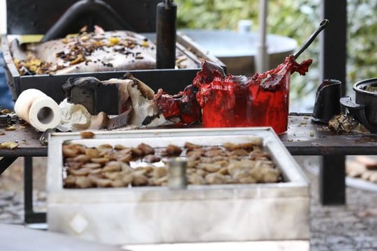 Verbrannte Grill-Utensilien liegen auf einem Tisch.