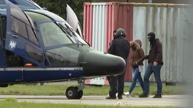 Vermummte Polizisten führen die Witwe des IS-Terroristen Denis Cuspert zu einem Hubschrauber der Bundespolizei.