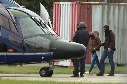 Vermummte Polizisten führen die Witwe des IS-Terroristen Denis Cuspert zu einem Hubschrauber der Bundespolizei.