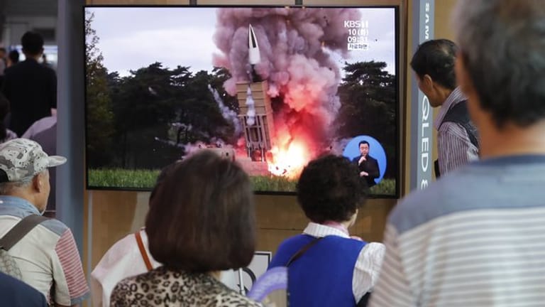 Passanten in Seoul schauen auf einem Fernseher einem Raketenstart Nordkoreas während einer Nachrichtensendung zu.