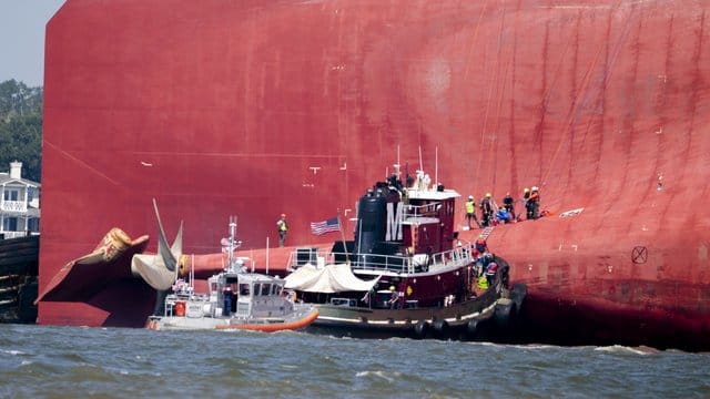 Rettungskräfte arbeiten in der Nähe des Hecks des Frachtschiffs "Golden Ray", welches mit Schlagseite im Meer liegt. Rettungskräfte arbeiten in der Nähe des Hecks des Frachtschiffs "Golden Ray", welches mit Schlagseite im Meer liegt.