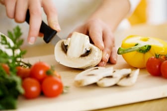 Pilze und Gemüse zubereiten: Die Ernährung spielt eine wichtige Rolle bei der Entstehung von Krankheiten.
