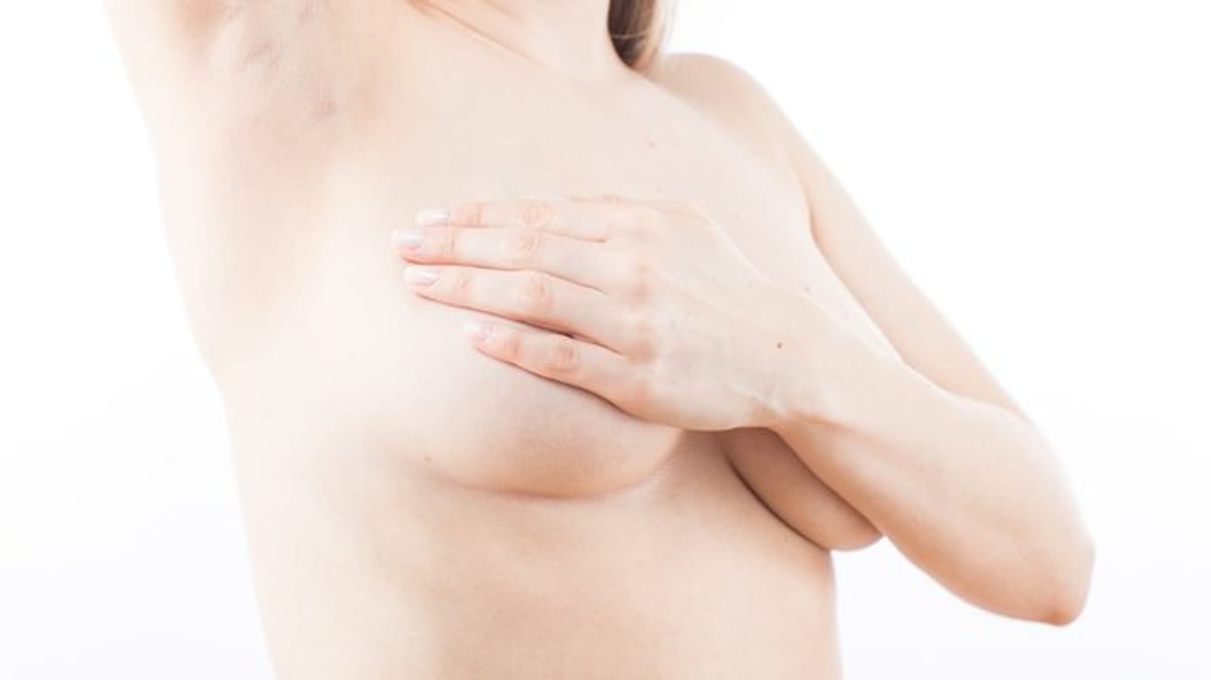 Eine Frau tastete die Brust ab: Beim Gynäkologen erfahren Frauen auch, wie sie ihre Brüste selbst untersuchen können.