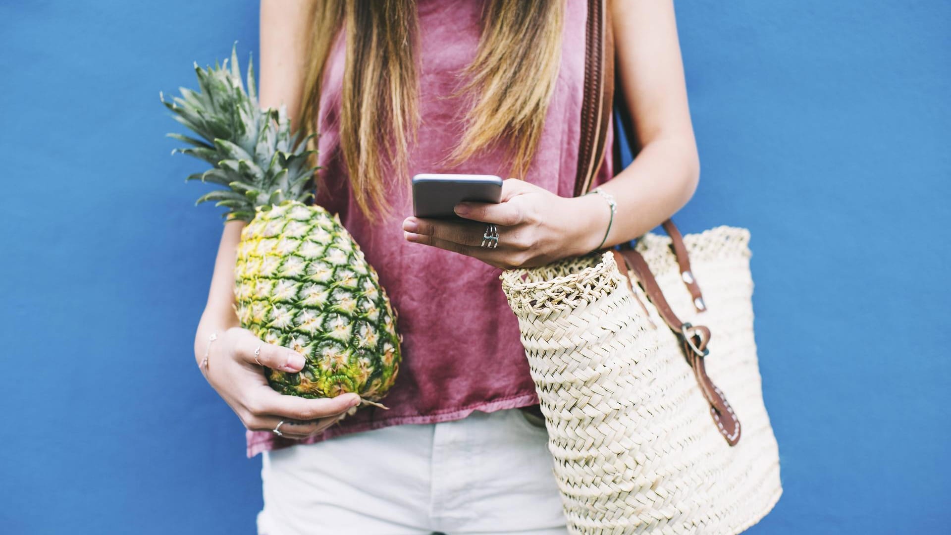 Frau hält Ananas: Passagiere von Alaska Airlines dürfen unter bestimmten Umständen zusätzlich zu ihrem normalen Gepäck noch eine frische Ananas mitnehmen.