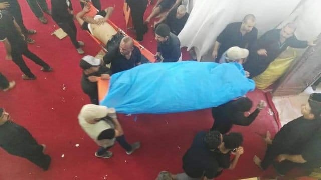 Männer tragen die Leiche eines bei der Massenpanik getöteten Gläubigen.