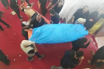 Männer tragen die Leiche eines bei der Massenpanik getöteten Gläubigen.