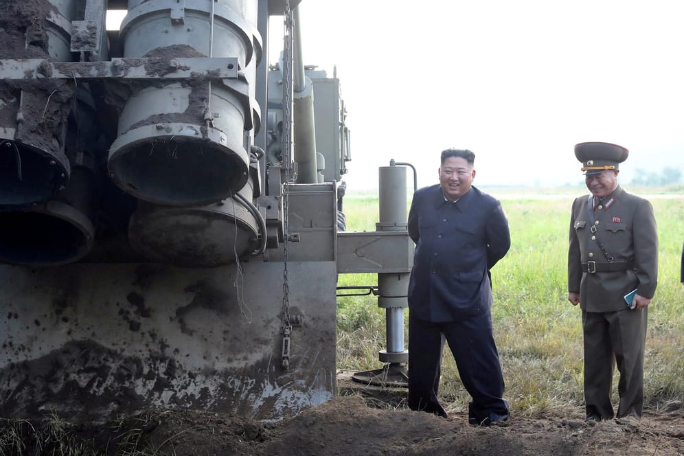Das von der nordkoreanischen Regierung zur Verfügung gestellten Foto zeigt Nordkoreas Machthaber Kim Jong Un (l), der einen Standort für Mehrfachraketenwerfer an einem unbekannten Ort in Nordkorea besucht.