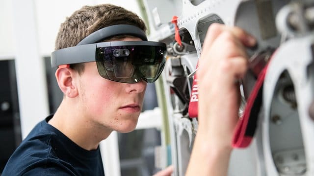 Ein Airbus-Auszubildender wird bei der Arbeit von einer Datenbrille unterstützt. Ein Airbus-Auszubildender wird bei der Arbeit von einer Datenbrille unterstützt.