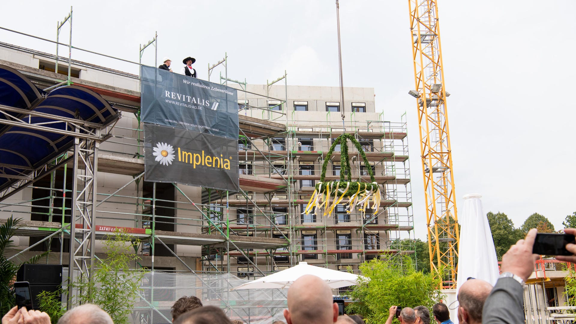 Ein Baukran zieht einen Kranz in die Höhe: In Dortmund hat eines der größten Wohnbauprojekte sein Richtfest gefeiert. Ein Baukran zieht einen Kranz in die Höhe: In Dortmund hat eines der größten Wohnbauprojekte sein Richtfest gefeiert.