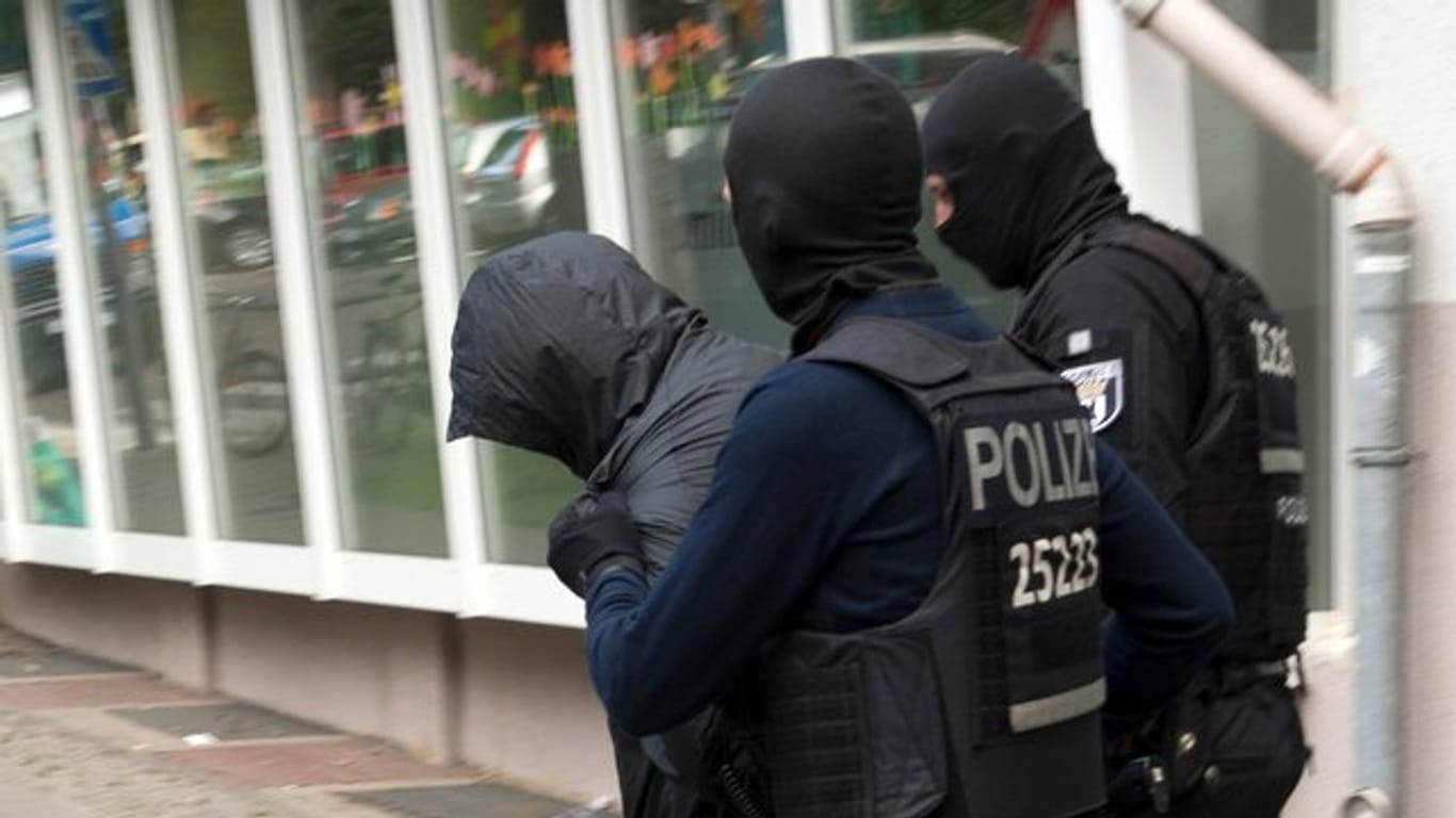 Polizeibeamte führen im Juli in Berlin einen Mann ab.