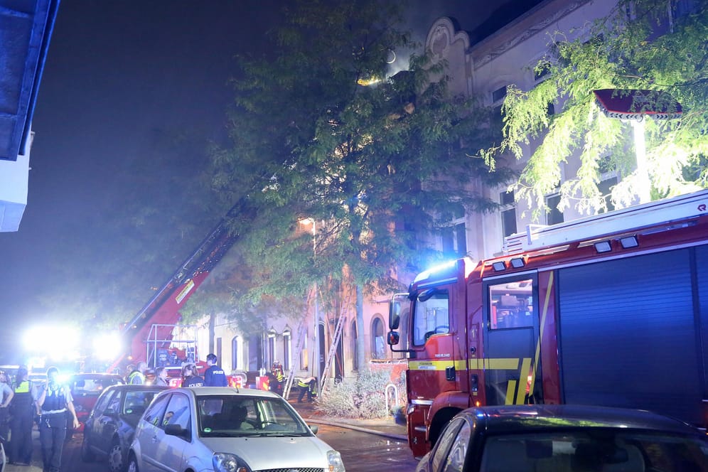 Feuerwehrleute löschen von einem Löschkorb aus den Dachstuhl des brennenden Hauses: Mindestens zwei Menschen sind bei dem Feuer in Krefeld gestorben.