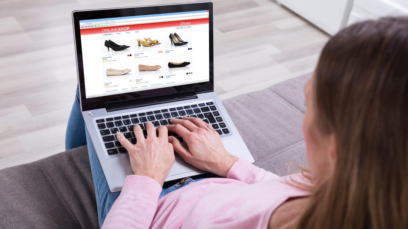 Eine Frau sitzt an ihrem Notebook: Bei unbekannten Onlineshops sollten Verbraucher vor der Bestellung das Impressum prüfen.