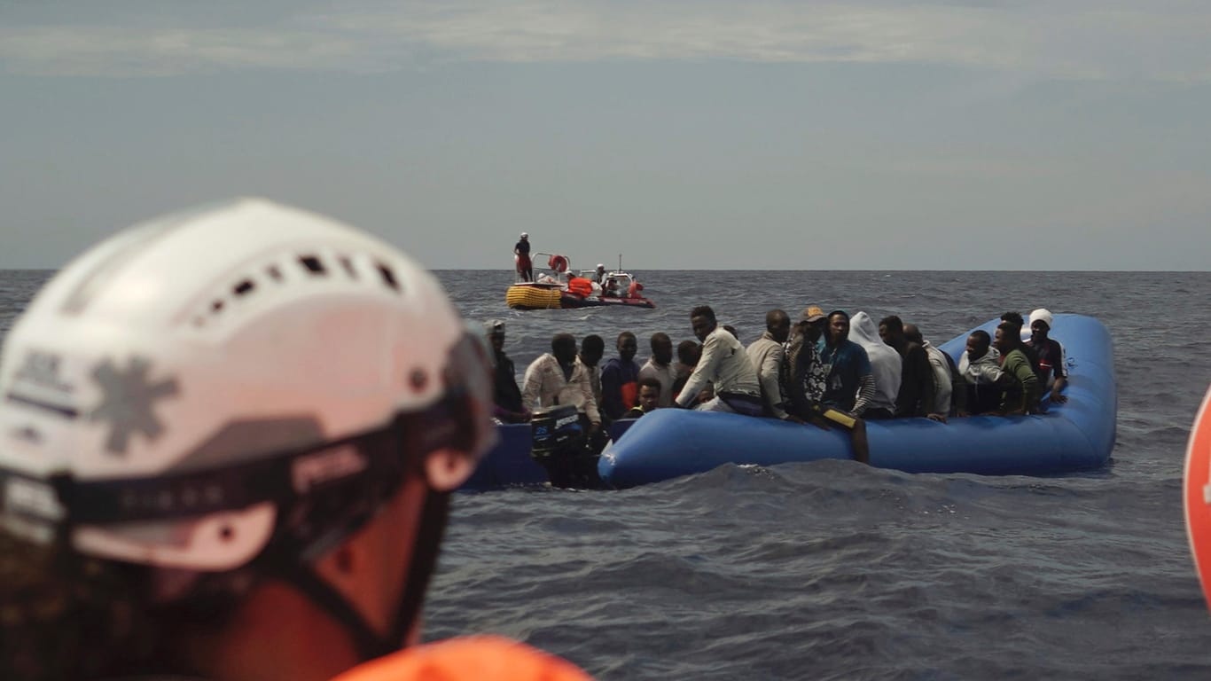 Migranten auf einem Gummiboot warten auf Rettung: Künftig will auch die evangelische Kirche auf dem Mittelmeer helfen.