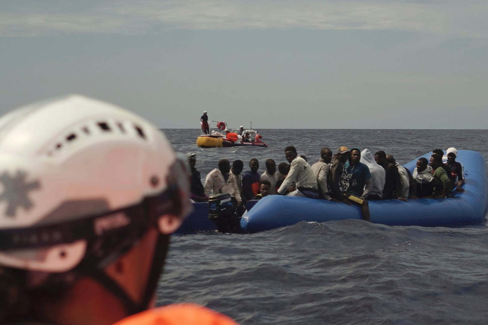 Migranten auf einem Gummiboot warten auf Rettung: Künftig will auch die evangelische Kirche auf dem Mittelmeer helfen.