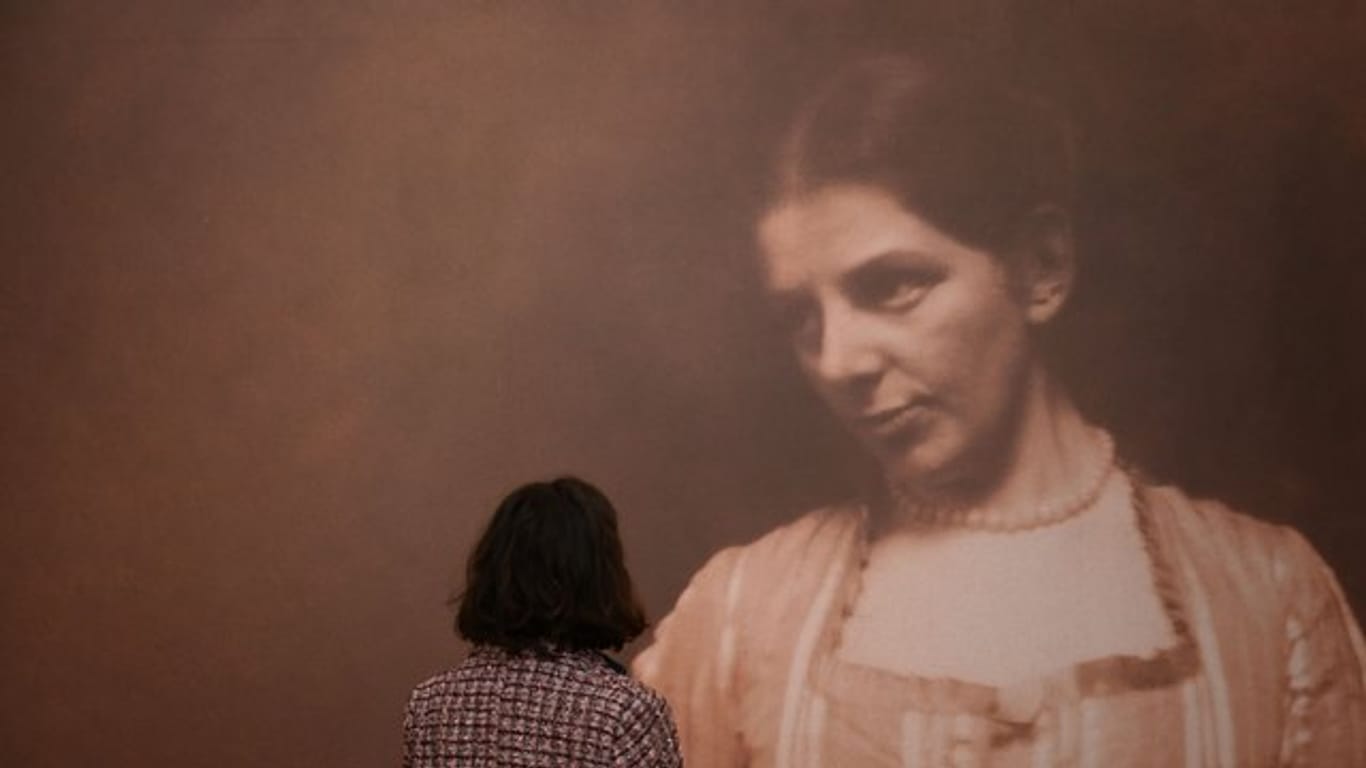 Eine Mitarbeiterin des Museums schaut sich ein Foto von Paula Modersohn-Becker, das um 1905 entstand, an.