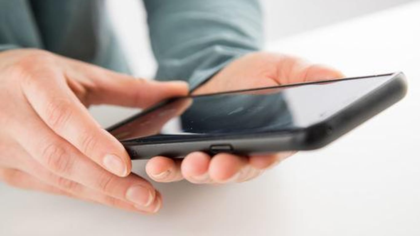 Ein Smartphone in der Hand: Ein gebrauchtes Handy sollten Käufer gründlich untersuchen.