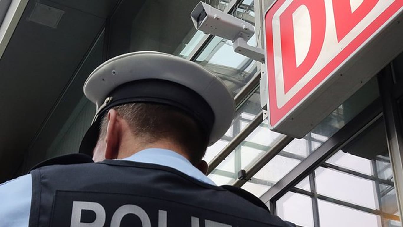 Ein Bundespolizist steht im Berliner Bahnhof Südkreuz unter einer Kamera für die Gesichtserkennung.