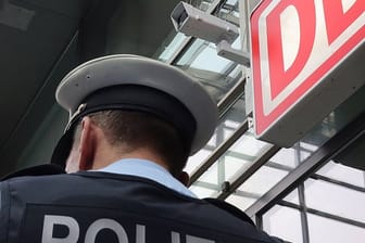 Ein Bundespolizist steht im Berliner Bahnhof Südkreuz unter einer Kamera für die Gesichtserkennung.