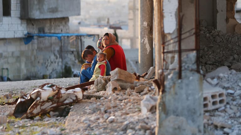 Frau mit Kindern in einem zerstörten Haus in Kobane: In der Stadt ist trotz der Kriegsverwüstungen viel Neues entstanden.