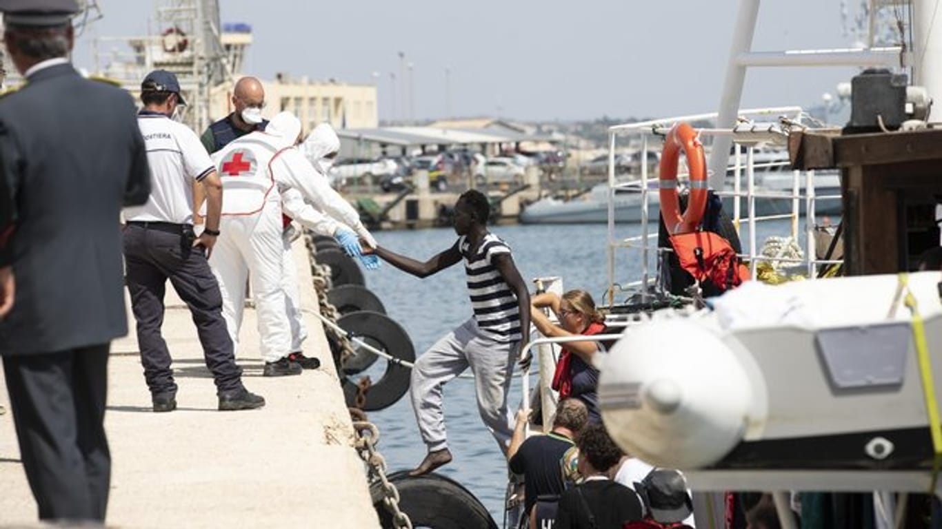 Migranten verlassen im Hafen von Pozzallo auf Sizilien ein Rettungsschiff.