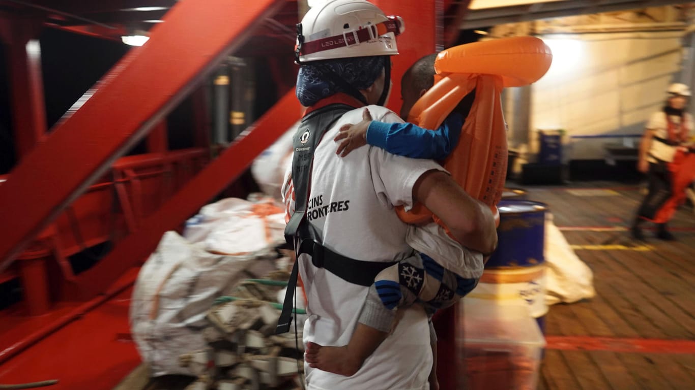 Ein Kleinkind wird auf dem Rettungsschiff «Ocean Viking» von einem Arzt getragen: Das Rettungsschiff «Ocean Viking» hat mehr als 80 Migranten auf dem Mittelmeer aufgenommen.