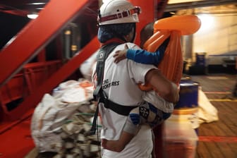 Ein Kleinkind wird auf dem Rettungsschiff «Ocean Viking» von einem Arzt getragen: Das Rettungsschiff «Ocean Viking» hat mehr als 80 Migranten auf dem Mittelmeer aufgenommen.