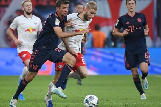 Leipzigs Konrad Laimer (M) im Laufduell mit Münchens Thomas Müller (l).